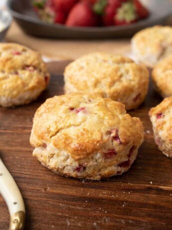 6 strawberry scones on a board with a butter knife