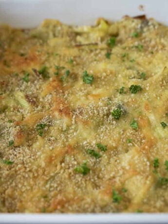 A crispy breadcrumb topping and chopped parsley on top of leeks in cheese sauce