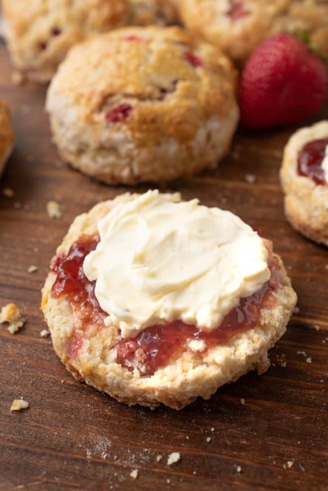 Half of a British Summer Strawberry Scone topped with strawberry jam and clotted cream