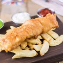 British fish and chips served with peas, ketchup and tartar sauce