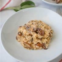 A white bowl of brown butter mushroom sage risotto