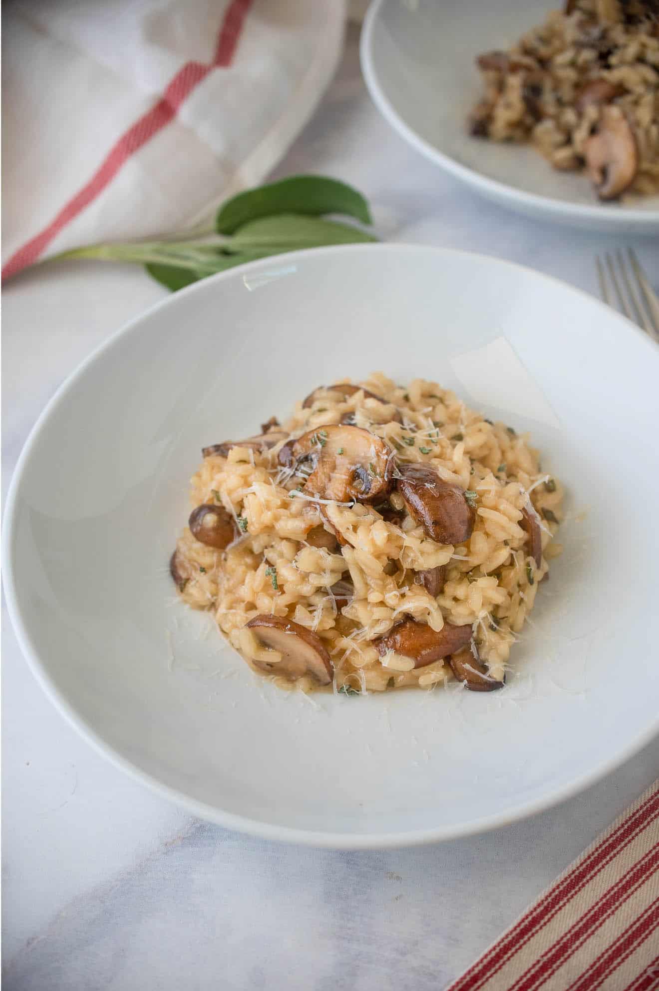 A white bowl of brown butter mushroom sage risotto