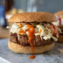 Bright orange buffalo sauce dripping down the side of a burger