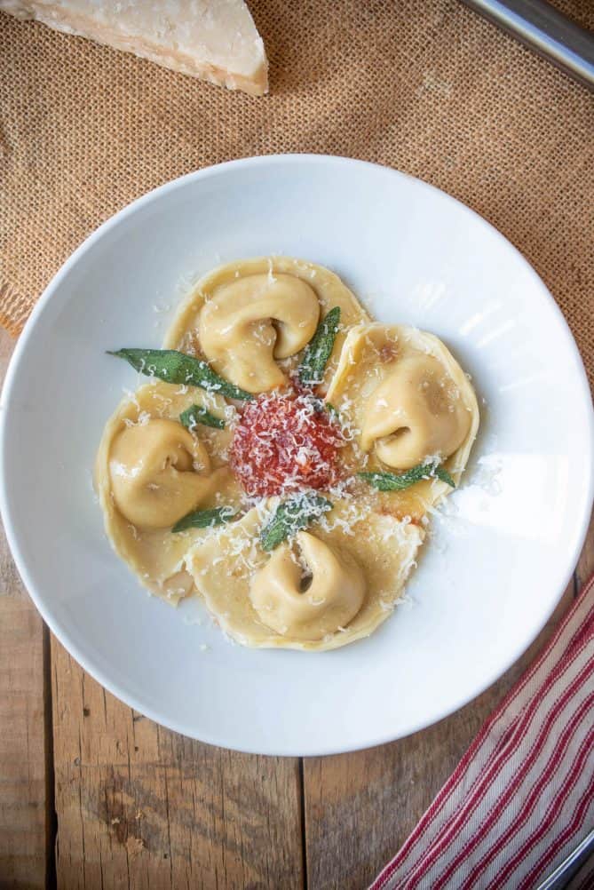 Cappellacci di zucca on a white plate viewed from overhead