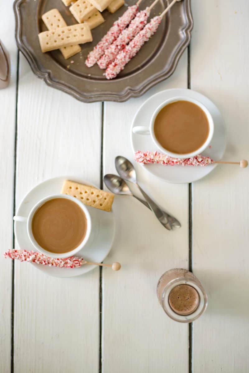 2 cups of coffee in white cups from overhead with spoons and cookies on a plate