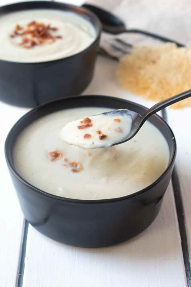 A spoonful of cauliflower and fennel soup with bacon