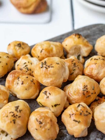 A selection of cheese, chive and rosemary puffs on a serving board
