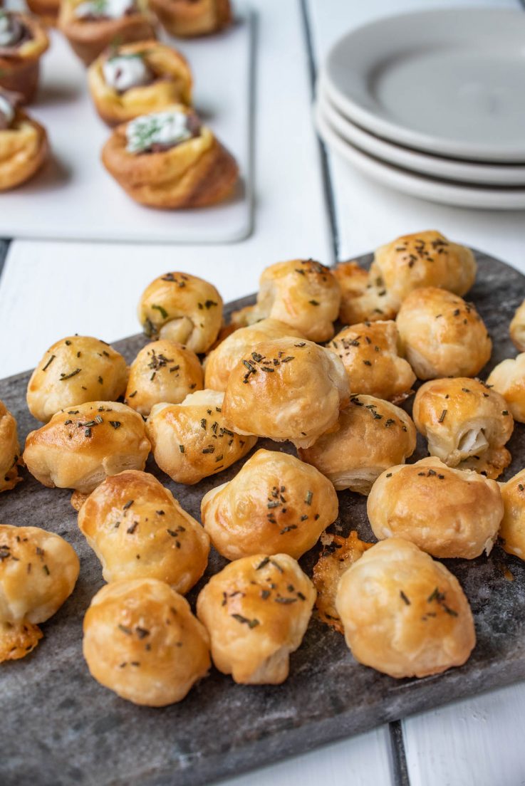 Mini puff pastry bites on a grey serving board