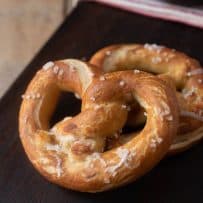 A closeup of a browned pretzel showing the coarse sea salt sprinkled on top