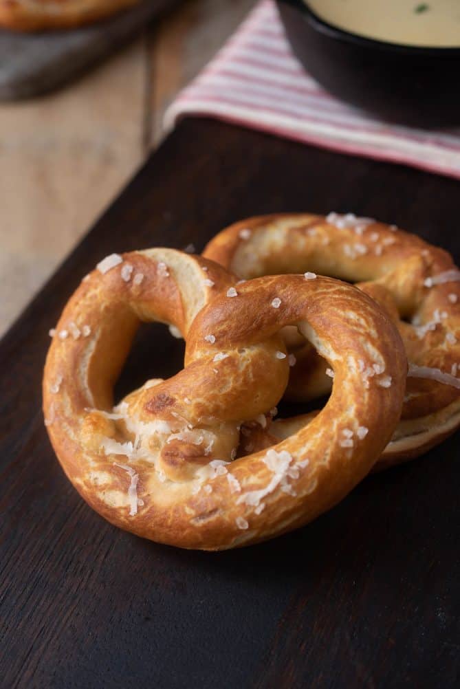 A closeup of a browned pretzel showing the coarse sea salt sprinkled on top
