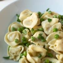 Tortellini mixed with butter, Parmesan and peas