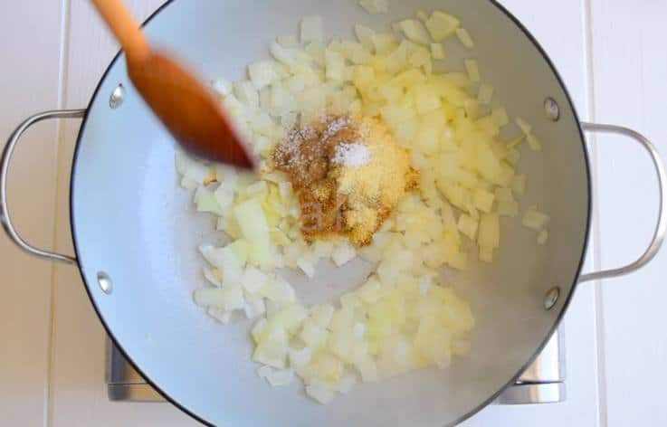 Onions are sauteed in a pan with Indian spices