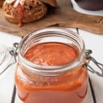 A jar of vibrant orange bbq sauce
