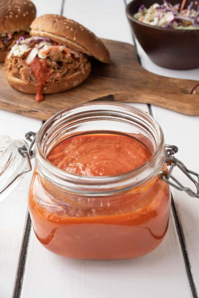 A jar of vibrant orange bbq sauce