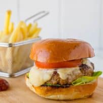 A thick chipotle chicken burger topped with melted cheese, tomato and lettuce