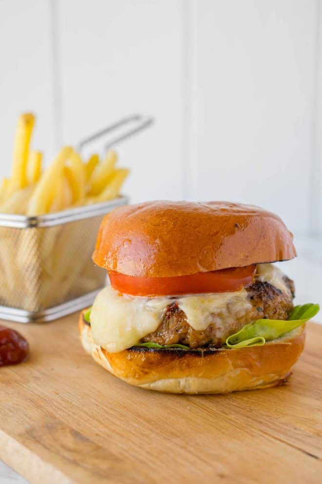 A thick chipotle chicken burger topped with melted cheese, tomato and lettuce