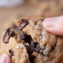 Breaking open a perfect chocolate chunk cookie with large sea salt flakes