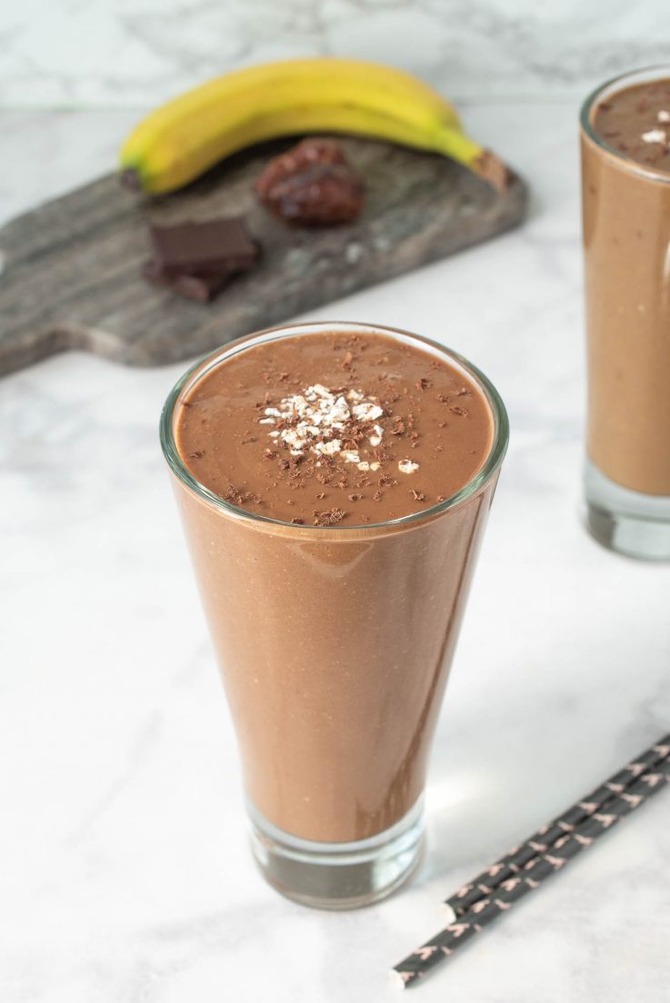 A tall glass filled with a chocolate smoothie