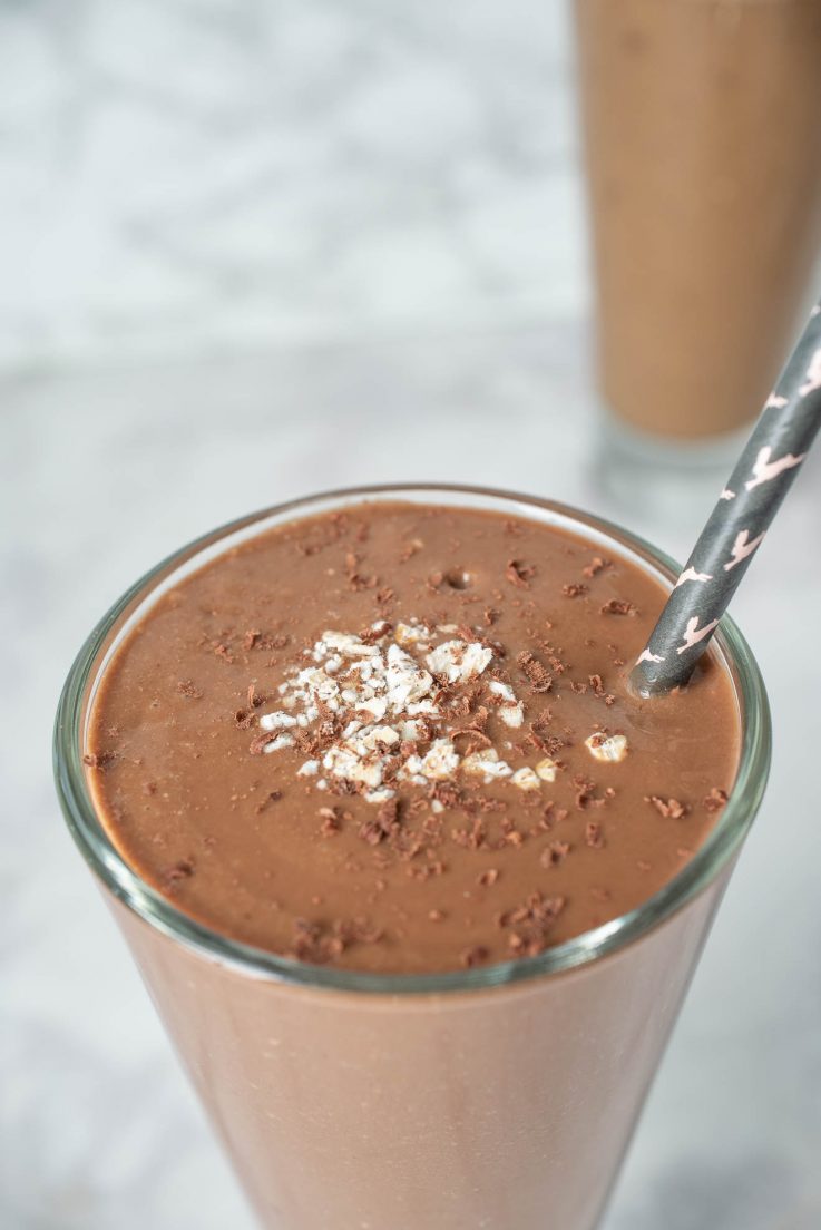 A closeup of the top of the smoothie with grated chocolate and oats