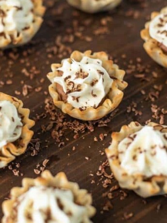 A selection of Chocolate Mousse Cream Cheese Phyllo Dessert Cups on a serving board with shaved chocolate