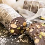 A closeup of a cut chocolate salami with nuts and cookie inside. Made to look like meat salami