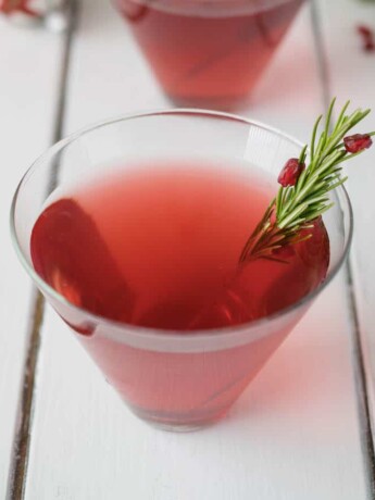 Christmas Cosmopolitan in a glass with fresh rosemary