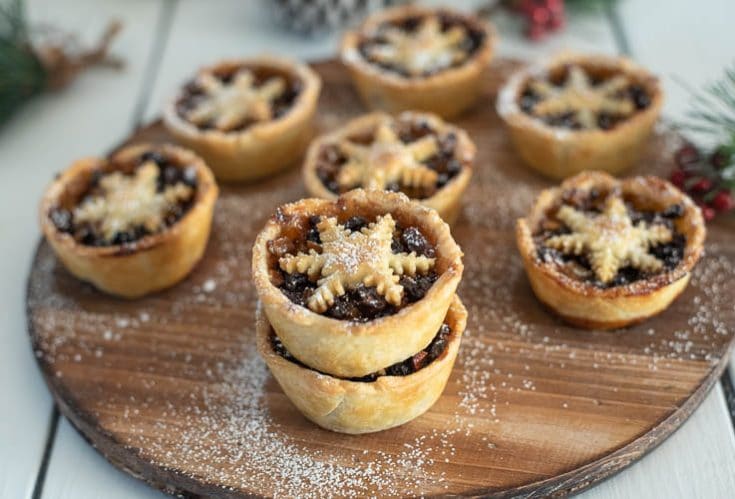 Christmas Sweet Mince Pies on a wood board dusted with powdered sugar