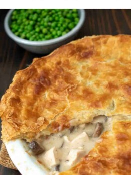 A closeup of a triangle piece taken from a chicken and mushroom pie