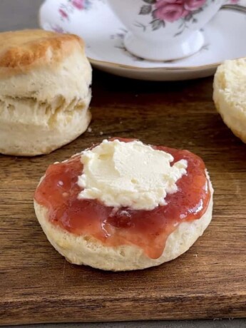 Fluffy homemade scones with strawberry jam and butter on wooden serving board, traditional breakfast bakery, soft baked pastries, fresh baked scones recipe, bakery dessert, culinary ginger image.