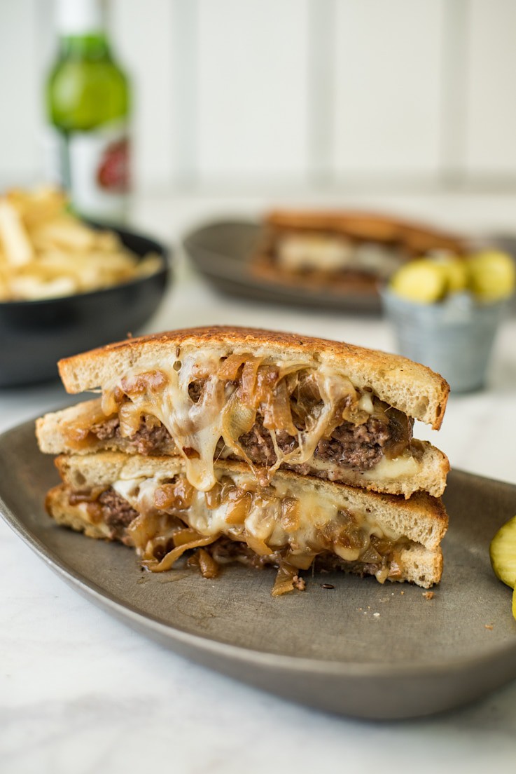 Classic Patty Melt Recipe cut in half showing caramelized onions and melted cheese