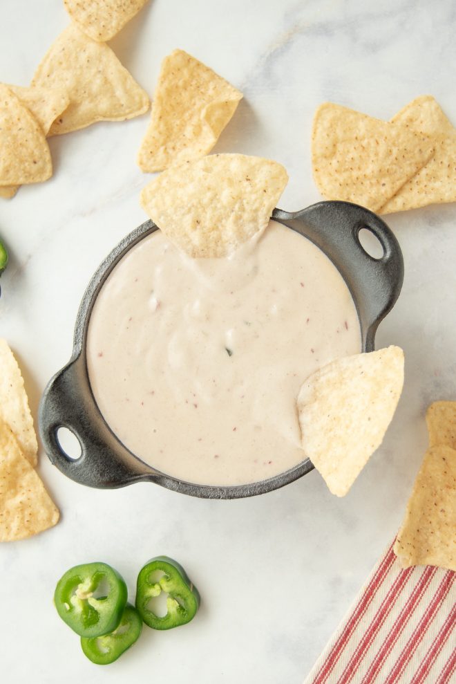 The queso from overhead with tortilla chips spread all around