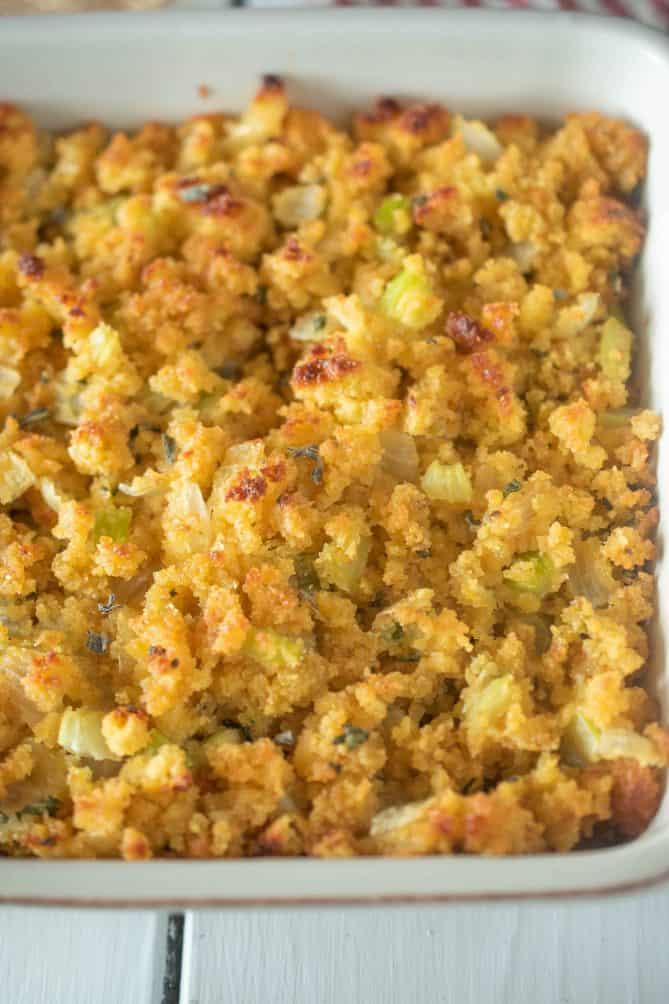 A closeup of cornbread with flecks of green celery, sage and onion