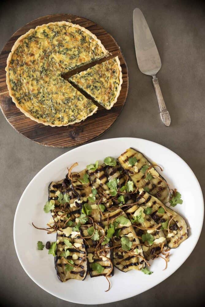 A platter of grilled aubergine/eggplant with a quiche.