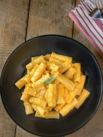 A black bowl filled with butternut squash pasta