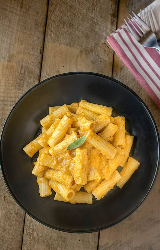 A black bowl filled with butternut squash pasta