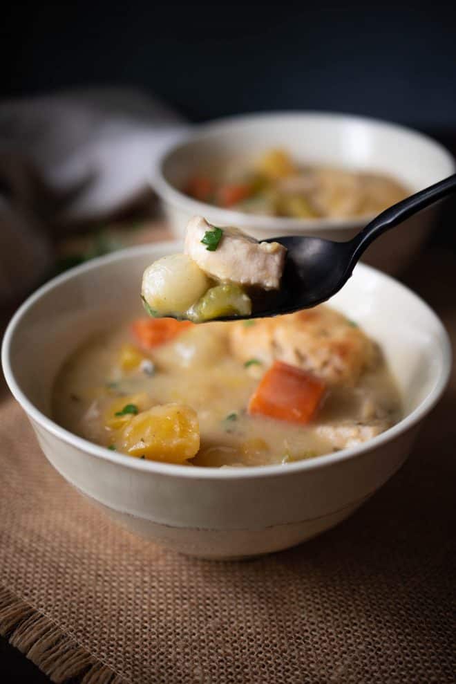 A spoonful of creamy chicken stew with sage and chive dumplings