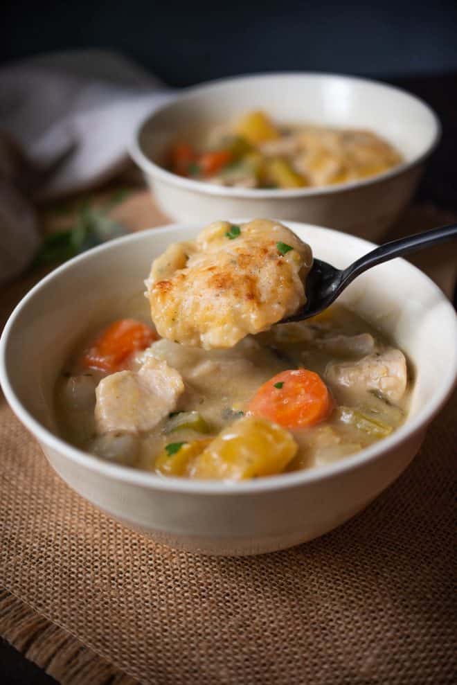 A dumpling on a spoon from Creamy Chicken Stew with Sage and Chive Dumplings