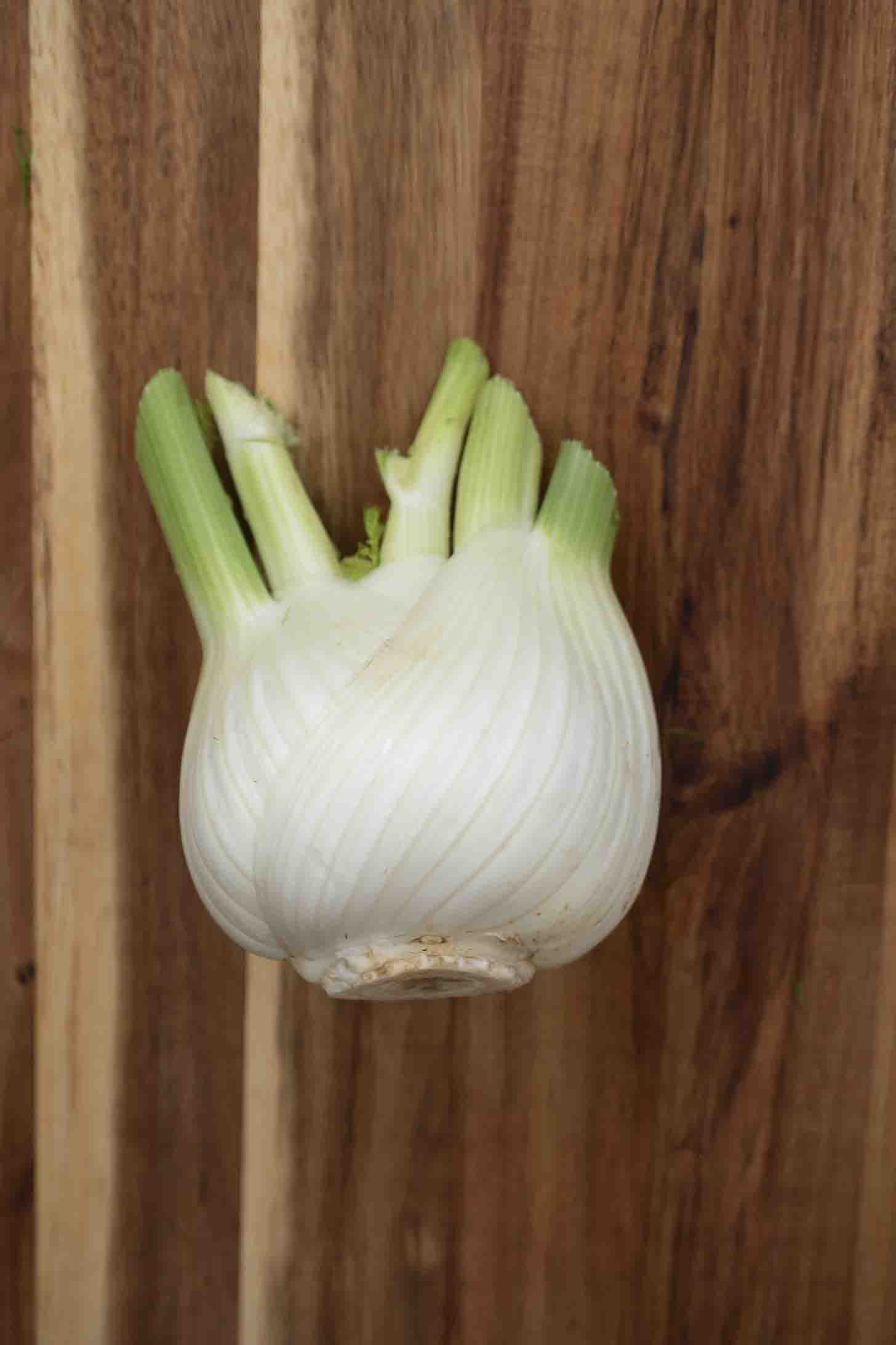 A trimmed fennel bulb on a cutting board
