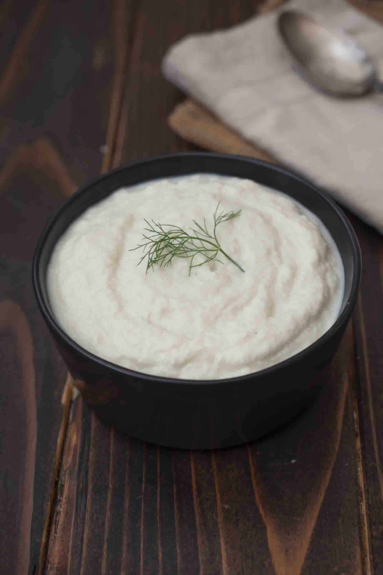 Creamy smooth fennel and leek puree in a black bowl
