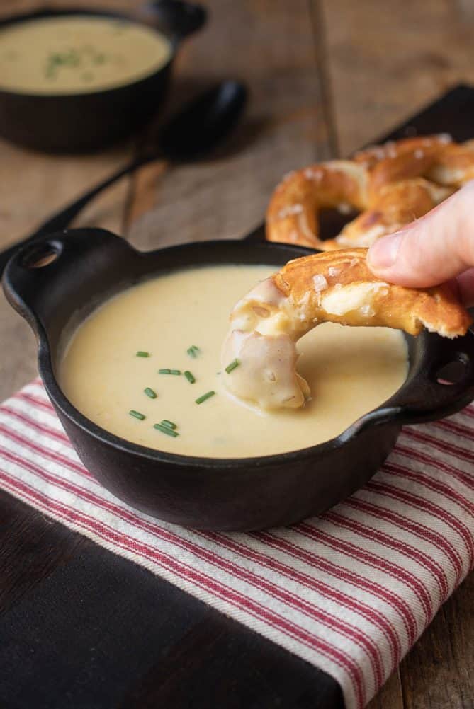 Dipping a soft pretzel into German beer cheese soup