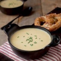 2 black bowls of creamy soup on a red and white striped napkin