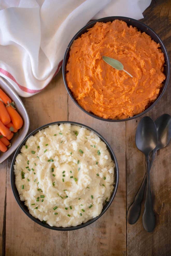 2 bowls of mashed potato, one with regular potatoes and one with yams/sweet potato