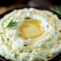 Butter melting on top of cauliflower mash with rosemary