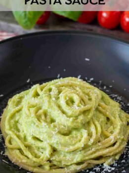 A closeup of zucchini, leek and basil pasta sauce in a bowl mixed with pasta