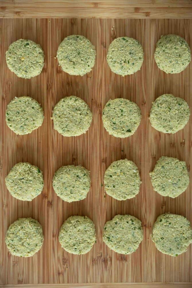 Uncooked falafel patties on a board