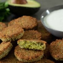 Small, round falafel patties with one cut in half showing the inside