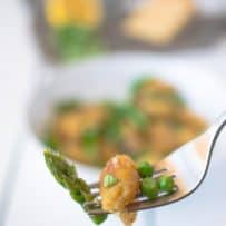 1 gnocchi on a fork with asparagus and peas