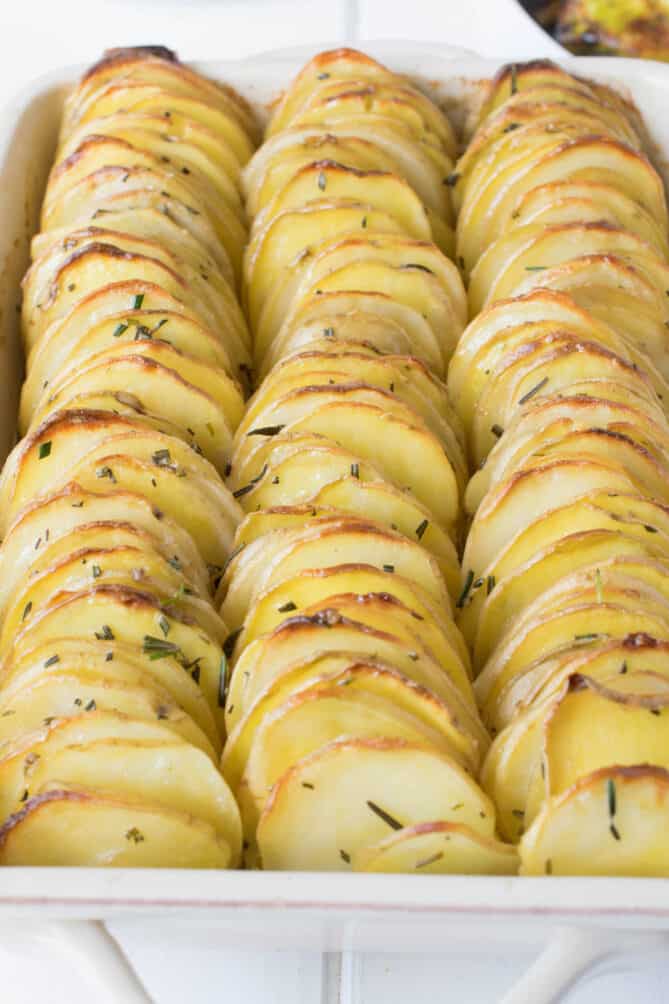 A closeup of thinly sliced potatoes layered in a baking dish