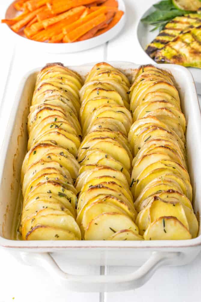 3 rows of sliced potatoes in a baking dish