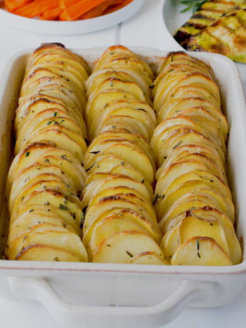 Thinly sliced potatoes lined up in roasting pan